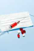 syringe and pills on blue background